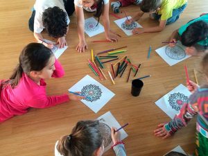 bambini che disegnano a lezione di yoga